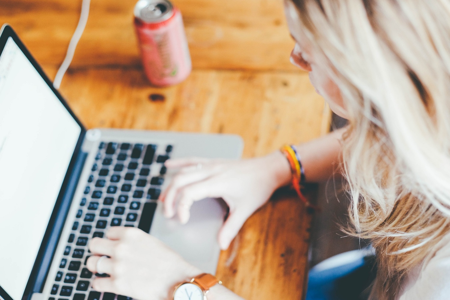 Computer / Bild von Welcome to All ! ツ auf eine junge Frau arbeitet an ihrem Laptop. Auf dem hölzernen Tische steht neben dem Laptop eine Sodadose.